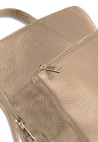 Sac en cuir doré métallisé avec surface texturée, doté d'une fermeture éclair bien visible et d'accents en métal élégant.