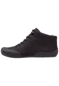 Black high-top shoes featuring a textured fabric upper, rubber toe cap, and a smooth sole with minimal detailing and lace closure.