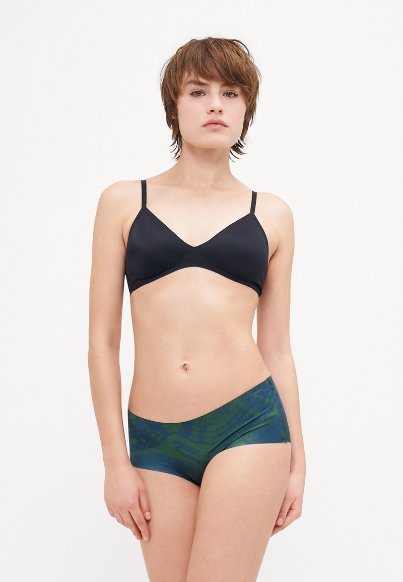 Black v-neck bralette with thin adjustable straps paired with green and blue patterned hipster shorts featuring a smooth fabric texture.