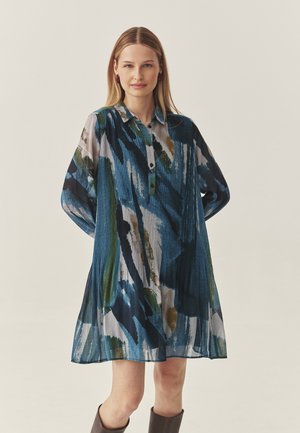 Langärmliges Hemdkleid im abstrakten Muster in Blau und Grün. Verfügt über eine durchgehende Knopfleiste, gepolsterte Textur und lockere Passform.
