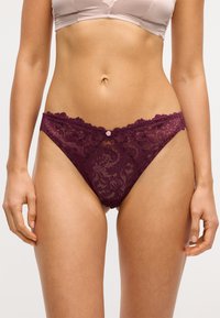 Burgunder lace trusse med blomsterprint, bølgede kanter og en lille dekorativ knap på den forreste talje. Blød, gennemsigtig tekstur.