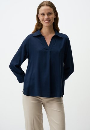 Navy blue long-sleeve shirt with a V-neck, made of smooth fabric; features a relaxed fit and side slits for ease of movement.