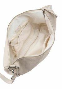 Sac à épaule beige avec un extérieur en suède doux, une fermeture zippée sur le dessus et un intérieur spacieux doublé comportant plusieurs poches et compartiments.