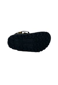 Suola in gomma nera con profili profondi e un pronunciato motivo a zigzag. Presenta il nome del marchio impresso e un tallone rinforzato.