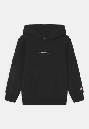 Haut à capuche noir en tissu doux avec une poche frontale, comportant un logo doré au centre et un petit logo sur la manche.