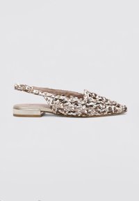 Zapatos planos tejidos con un brillo metálico en tonos beige y dorado, con un tacón bajo y una correa en el tobillo ajustable.