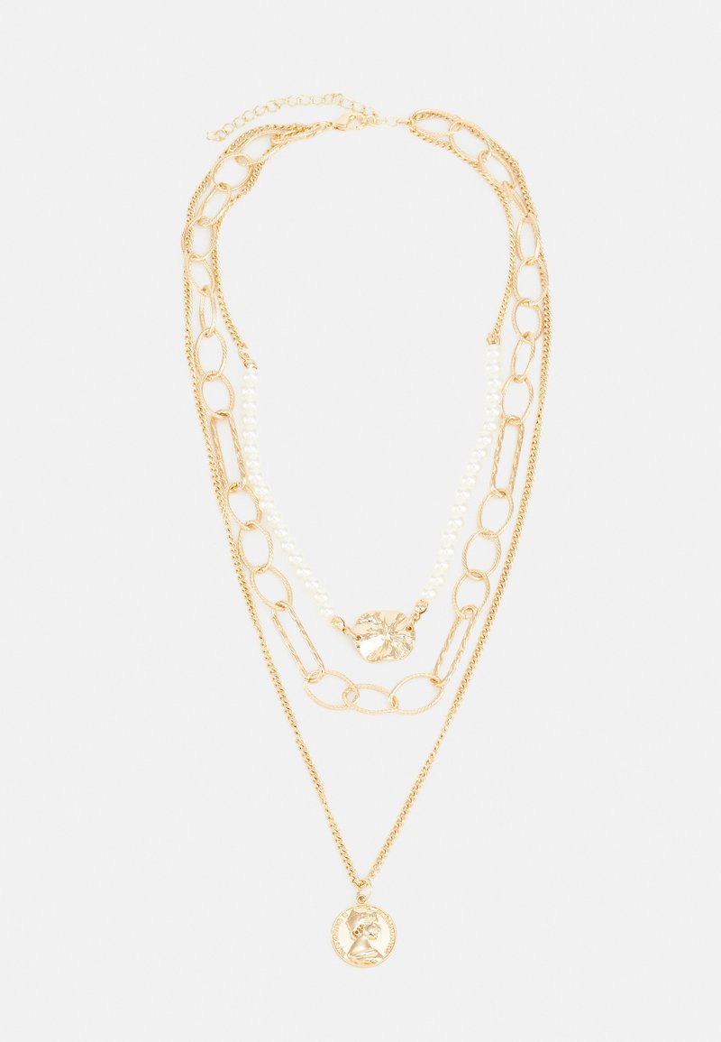 Lagdelte guld kæder med snoede led og perler samt en detaljeret medaljon vedhæng. Forskellige teksturer skaber visuel interesse.