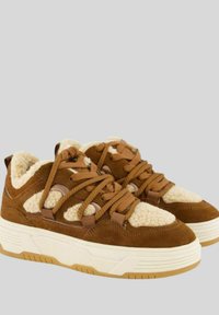 Sneaker in suede marrone con accenti di tessuto crema e lacci spessi. Presenta una suola in gomma bianca chunky e una punta arrotondata.