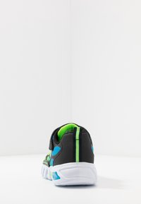 Czarne sneakersy z jaskrawymi zielonymi i niebieskimi akcentami, siateczkowa cholewka, gumowa podeszwa oraz unikalny teksturowany wzór wzdłuż boków i pięty.