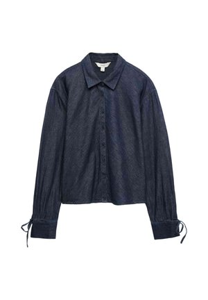 Ciemnoniebieska, długi rękaw, koszula jeansowa na guziki z kołnierzykiem i troczkami przy mankietach, rozłożona na płasko na białym tle.