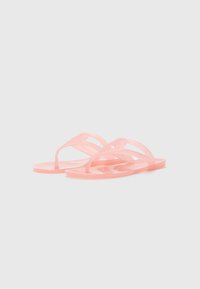 Rosa genomskinliga flip-flops med platt sula och tunna remmar som har en cirkulär accent på varje rem. Slät och glänsande yta.
