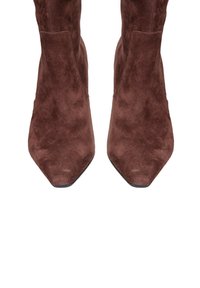 Stivali alla caviglia in suede marrone con design a punta e silhouette slanciata. Presentano una texture liscia e uno stile minimalista senza decorazioni.