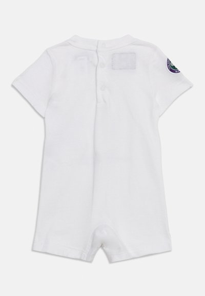 Body blanc à manches courtes pour bébé avec fermeture à pression dans le dos et un patch circulaire sur la manche gauche.