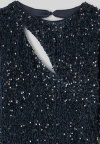 Robe bleu marine avec une surface texturée couverte de paillettes brillantes. Présente une découpe en forme de trou de serrure à l'arrière et un col rond.