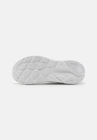 Suela de zapatilla deportiva blanca con goma texturizada, que presenta diversas formas para mejorar el agarre. Sección central lisa con un estampado de logo.
