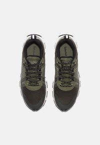 Grüne Sportschuhe mit einem atmungsaktiven Mesh-Obermaterial, schwarzen Akzenten, strukturiertem Design und einer weißen Gummisohle. Schnürverschluss.