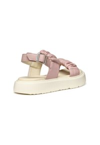 Sandalia sintética acolchada y rosa con tiras cruzadas y hebilla metálica ajustable. Presenta una suela blanca gruesa y texturizada. Sin patrones ni adornos.