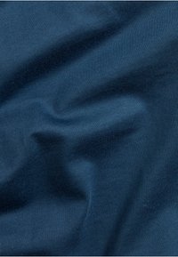 Mørkeblåt tekstureret stof med subtil ribbning. Materialet ser blødt ud, med blide folder og variationer i lys og skygge.