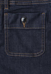 Poche en denim bleu foncé avec coutures orange et un seul bouton noir au centre en haut de la poche.