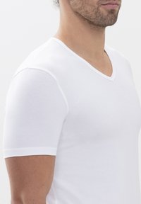 White short-sleeve V-neck t-shirt, made of soft fabric, featuring a smooth texture and subtle contrast stitching along the neckline.