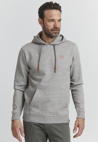 Hellgraue Kapuzenjacke aus strukturiertem Material, mit einer Fronttasche, Zugbändern mit orangen Akzenten und einem kleinen Logo auf der Brust.