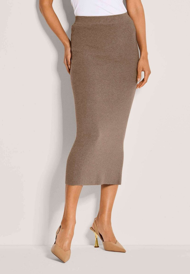 Bruine gebreide kokerrok met een hoge taille, een slim-fit vorm en een zachte textuur. Gecombineerd met beige slingback hakken met gouden accenten.