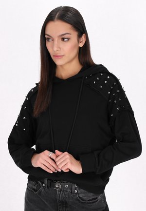 Zwarte hoodie met metalen studs op de schouders, trekkoordcapuchon, voorzak en geribbelde manchetten, gemaakt van zacht materiaal.