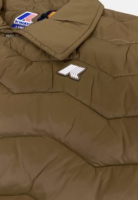 Giubbotto oversize marrone con imbottitura, caratterizzato da un design trapuntato, un ampio colletto e una toppa del logo K-Way bianca. Il materiale sembra liscio con una finitura lucida.