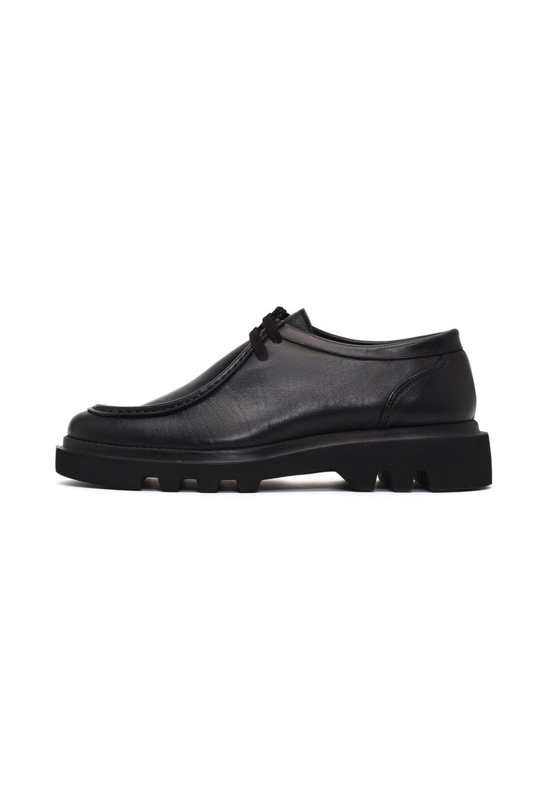 Zwarte leren schoenen met een ronde neus, een laag profiel en een gestructureerd oppervlak. Voorzien van een dikke, robuuste zool met zichtbare profielpatronen.