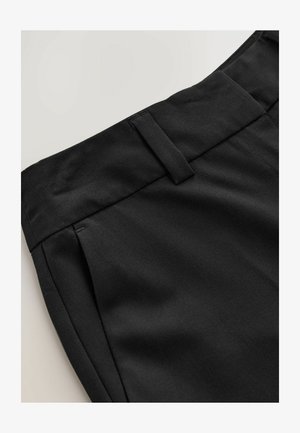 Zwarte op maat gemaakte broek met een rechte voorkant, zijzakken en een gladde stoftextuur. De tailleband heeft riemlussen voor stylingopties.