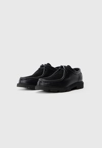 Schwarze Lederschuhe mit strukturierter Oberfläche, runder Zehenpartie und kontrastierenden Wildlederakzenten. Mit solider Gummisohle und Schnürdesign.