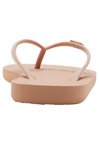 Flip-flops roz din cauciuc, cu un branț texturat și curele subțiri în formă de Y. Talpa este plată și ușor conturată pentru confort.
