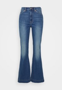 Modré džíny s rozšířenými nohavicemi a vysokým pasem, s vybledlými detaily a šitými švy, vyrobené ze středně těžké bavlněné látky.