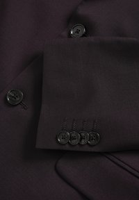 Sacou violet închis cu o textură netedă, patru nasturi negri pe manșetă și un nasture singular la guler cu detalii de cusătură.