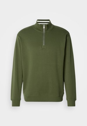 Zelen pulover s četrtinskim zadrgo, narejen iz gladkega materiala, z visokim ovratnikom in rebrastimi manšetami. Preprost dizajn z minimalnimi detajli.