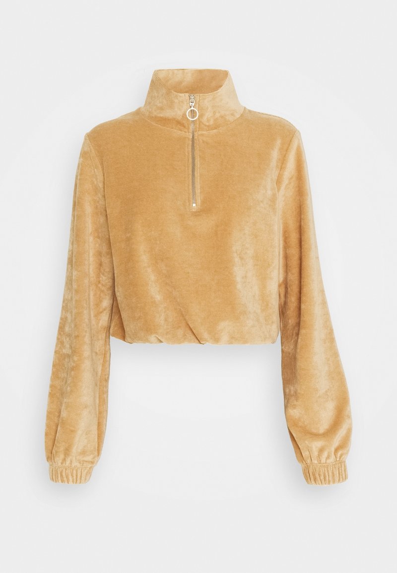 Pull court en velours beige avec manches longues, col montant, demi-fermeture éclair avec tirette anneau et poignets élastiques.