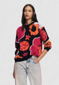 Maglione lavorato a maglia di colore nero con grande motivo floreale in rosa, arancione e bianco. Caratterizzato da un colletto rotondo e polsini e orlo a coste. Vestibilità casual.