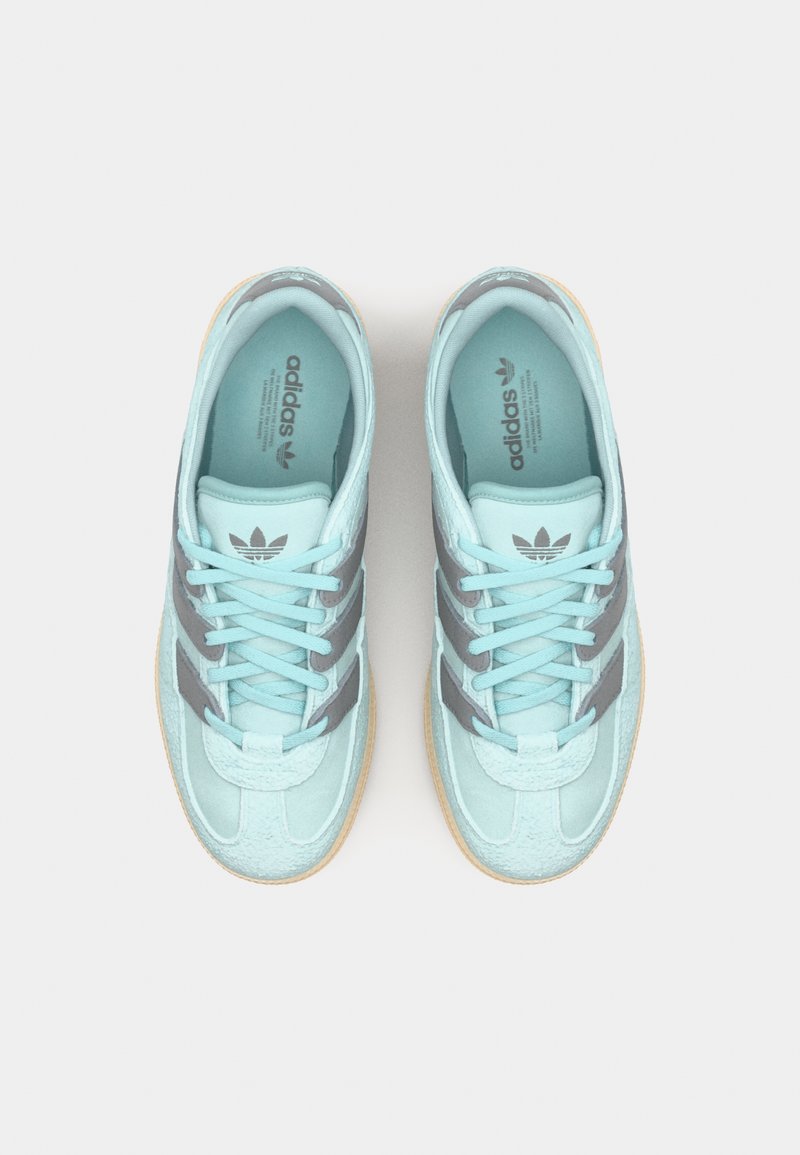 Hellblaue Wildleder-Sneaker mit grauen Streifen, flachen Schnürsenkeln, gepolstertem Kragen und einer Gummisohle. Adidas-Logo auf der Zunge und der Innensohle.