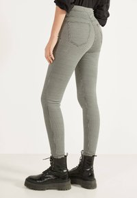 High-waisted black and white checkered leggings with back pockets, paired with black lace-up platform boots featuring a textured finish.