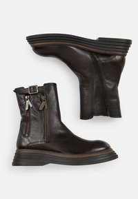 Botas negras de cuero hasta el tobillo con puntera redondeada, dobles cremalleras laterales y una suela de goma estratificada. Presentan un acabado texturizado y detalles de hebilla.