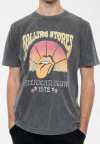 Gray cotton t-shirt featuring a vintage Rolling Stones graphic with orange and yellow sunset, cactus accents, and "American Tour 1972" text.