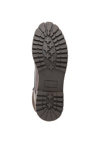 Bruine rubberen zool met diepe looppatronen en kruisdetails. Heeft een gemarkeerd gedeelte met het merk "TRAVELIN" en maat "42."