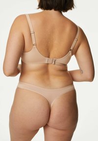 Nude beha en string set gemaakt van glad materiaal, met verstelbare banden, een haaksluiting en een minimalistisch ontwerp zonder patronen.