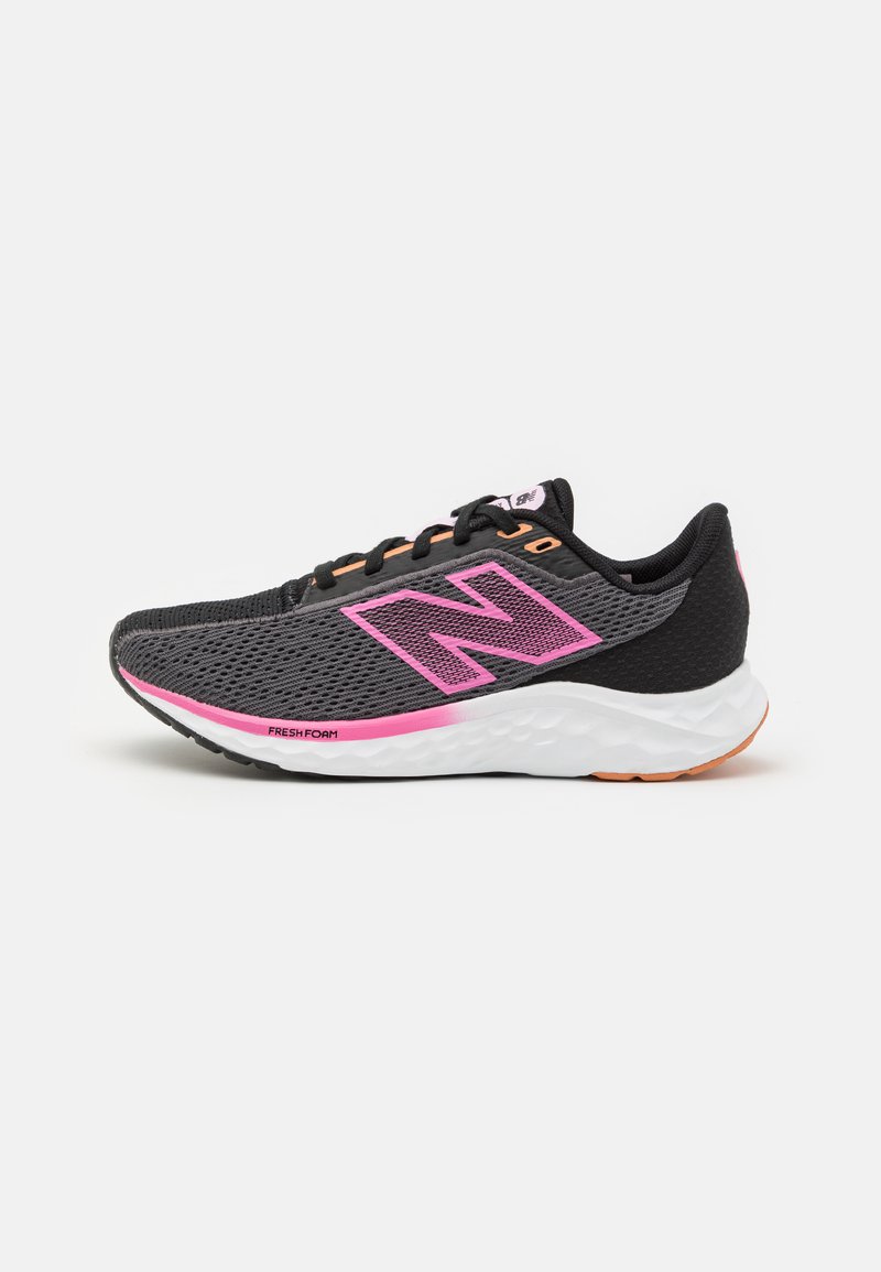 Zapatilla de running negra de malla con un logo y acentos en rosa. Cuenta con una suela blanca acolchada y una suela externa texturizada para tracción.