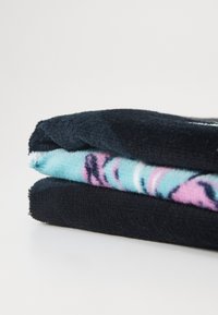 Duas toalhas empilhadas: uma preta e uma azul clara com padrões abstratos em rosa e preto, ambas feitas de um tecido suave e texturizado.