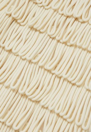 Tessuto di crema texturizzato con anse, creando un motivo ondulato. Fili morbidi e flessibili disposti in orizzontale, che aggiungono volume e profondità.
