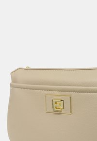 Borsa in pelle beige con una texture liscia, dotata di una chiusura rettangolare in metallo dorato. Design semplice e linee pulite.