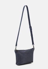 Marinblå axelväska i texturerad konstläder. Har dragkedjeslutning, justerbar rem och subtilt präglat mönster.