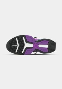 Semelle d'une chaussure de sport violet et noir avec des accents blancs et une bande de roulement en caoutchouc Continental visible sur un fond blanc.