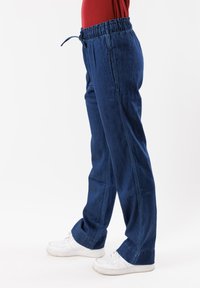 Pantaloni denim blu con vita elasticizzata e lacci, caratterizzati da un design a gamba dritta e dettagli di cucitura discreti sui lati.